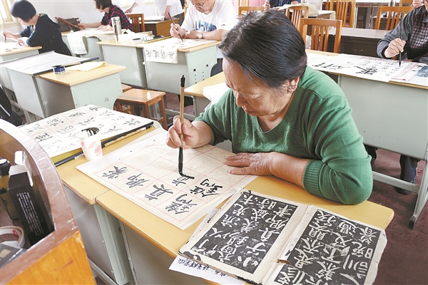 金港鎮(zhèn)老年大學書法班學員正在認真臨摹。.jpg
