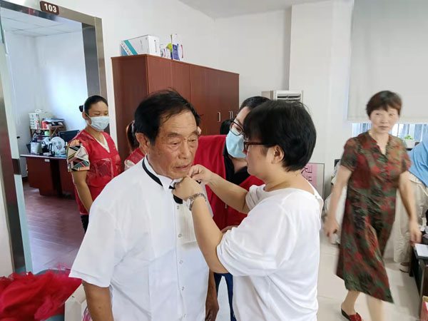正在幫居民整理領(lǐng)結(jié)的靈巖社區(qū)分院校長(zhǎng)賀丹.jpg