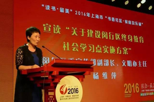圖六：閔行區(qū)學(xué)促委副秘書長、區(qū)委宣傳部副部長、文明辦主任楊維萍宣讀《關(guān)于建設(shè)閔行區(qū)終身教育社會(huì)學(xué)習(xí)點(diǎn)的實(shí)施方案》.jpg